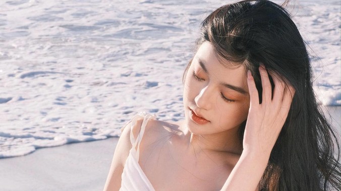 浅灰沙滩场景的4K壁纸,长发人物侧影与细腻海浪,背景含晨雾柔光效果