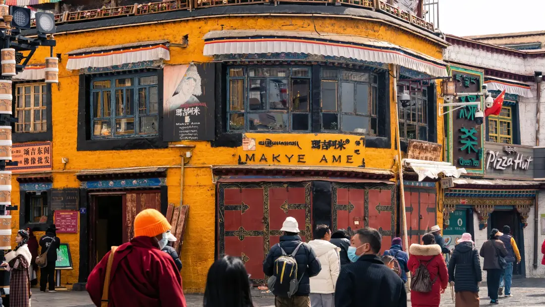 藏式玛吉阿米建筑在拉萨八廓街的橙黄色外立面与行人互动场景