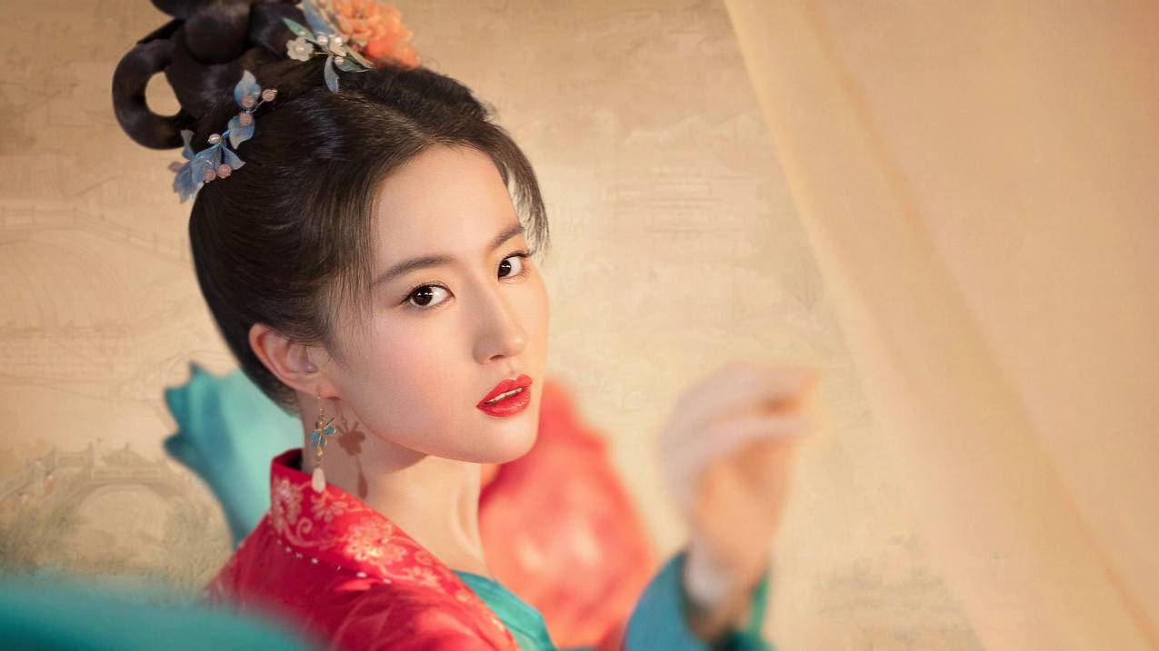 身着赤朱青绿古装的刘亦菲在《梦华录》中回眸凝望,头戴金凤步摇妆容精致的古典美人形象